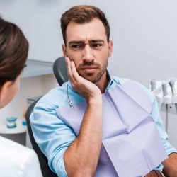 man at dentist with toothache What to Do in General Dental Emergencies